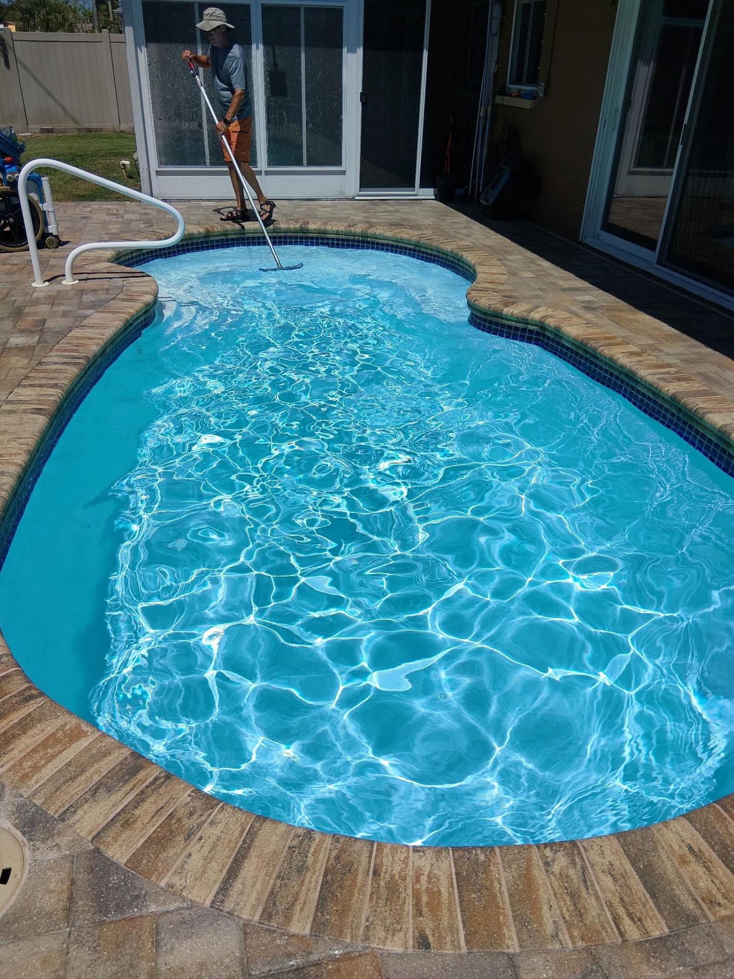 Technician brushing a residential Florida pool